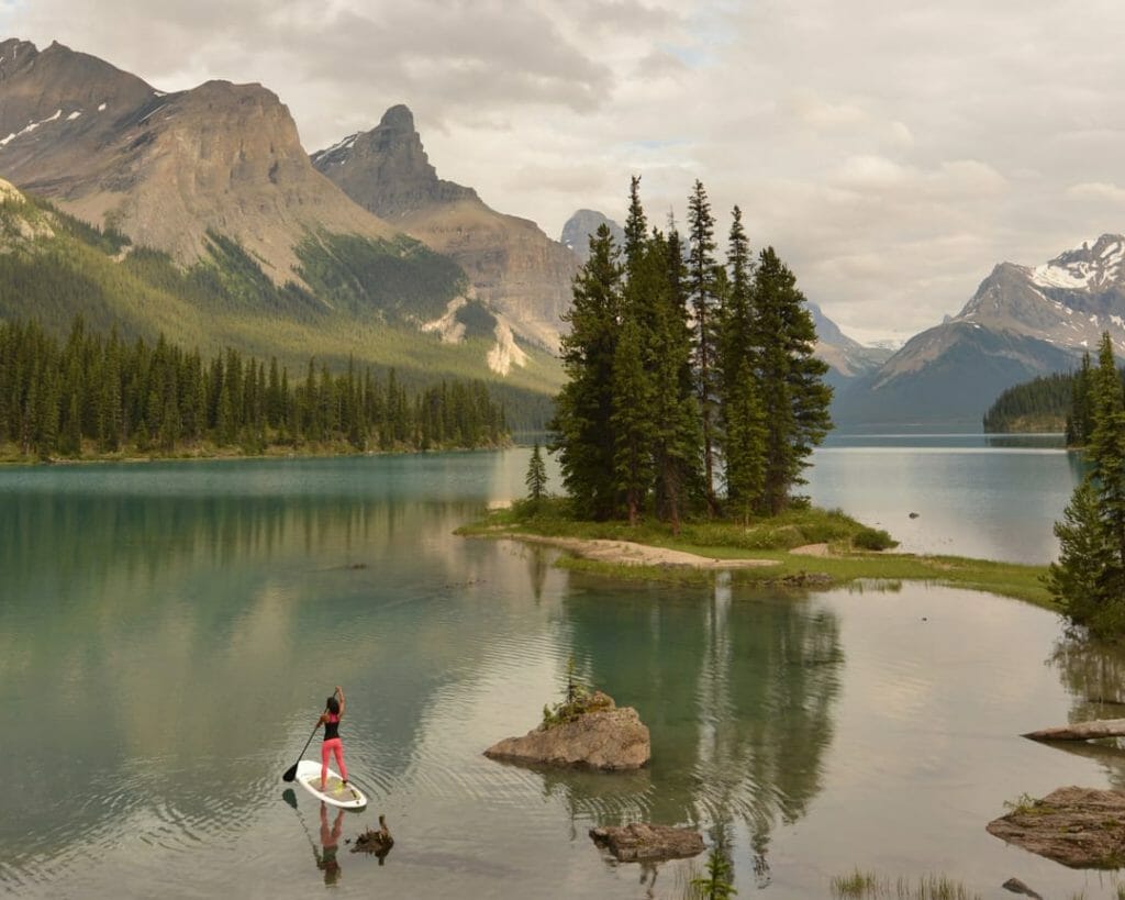 Woman standup paddle boarding on a large alpine lake