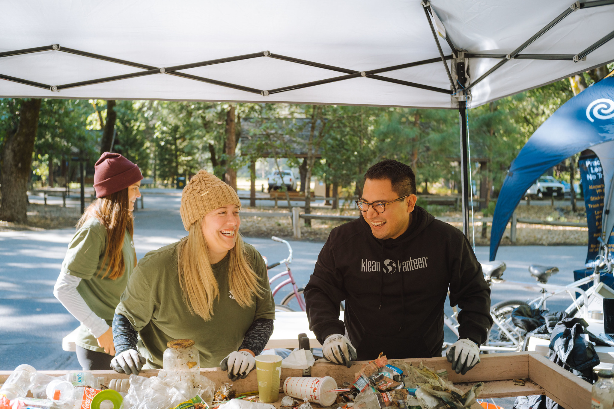 Duas pessoas separam os materiais recicláveis do lixo.